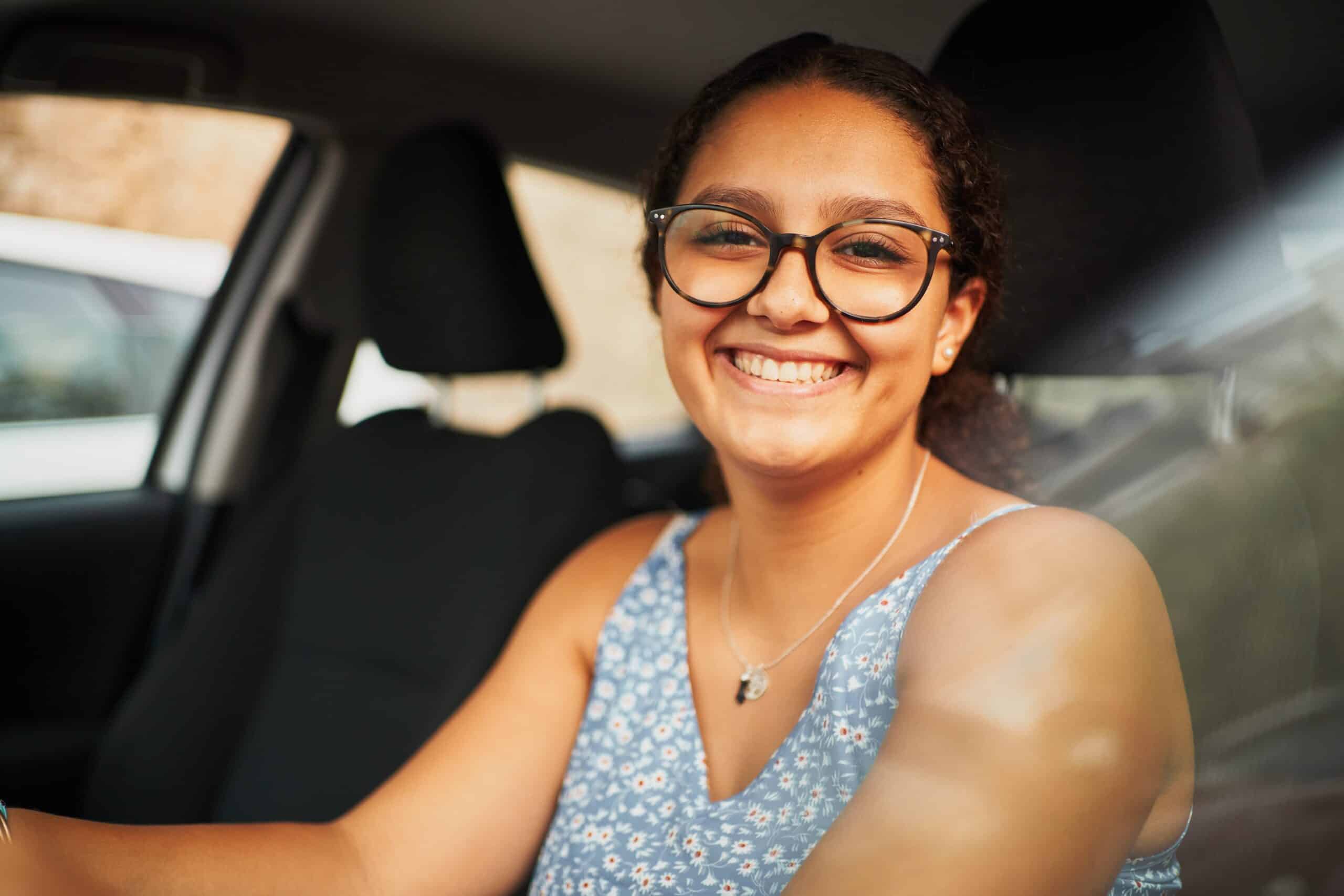 Woman smiling in the driver seat of her car